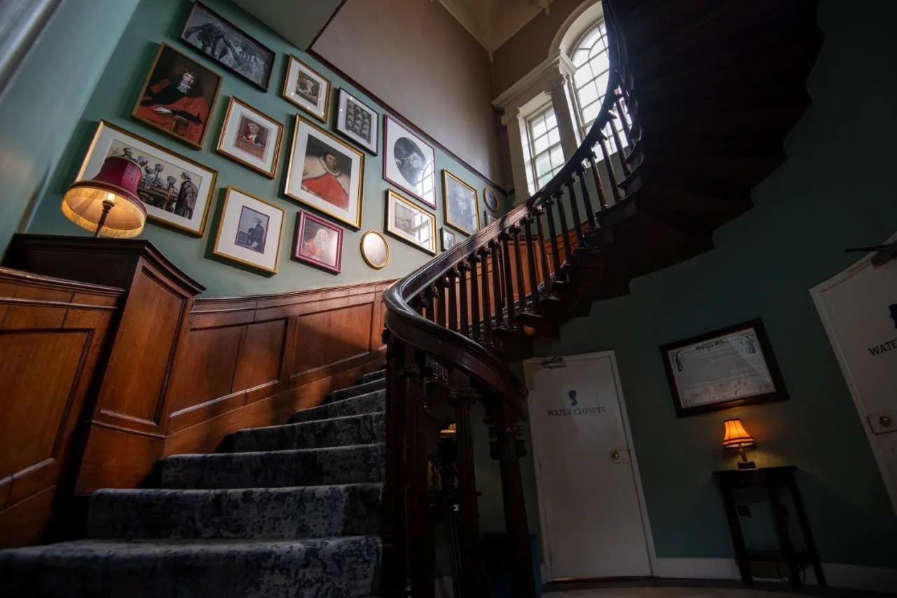 A staircase lined with pictures inside the Georgian townhouse at Judge's Lodging in York