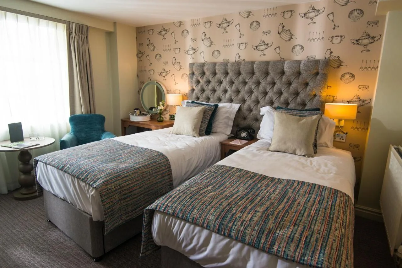 A hotel room with two beds and a large headboard at Judge's Lodging in York